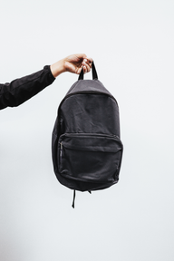 Black backpack held by its top handle
